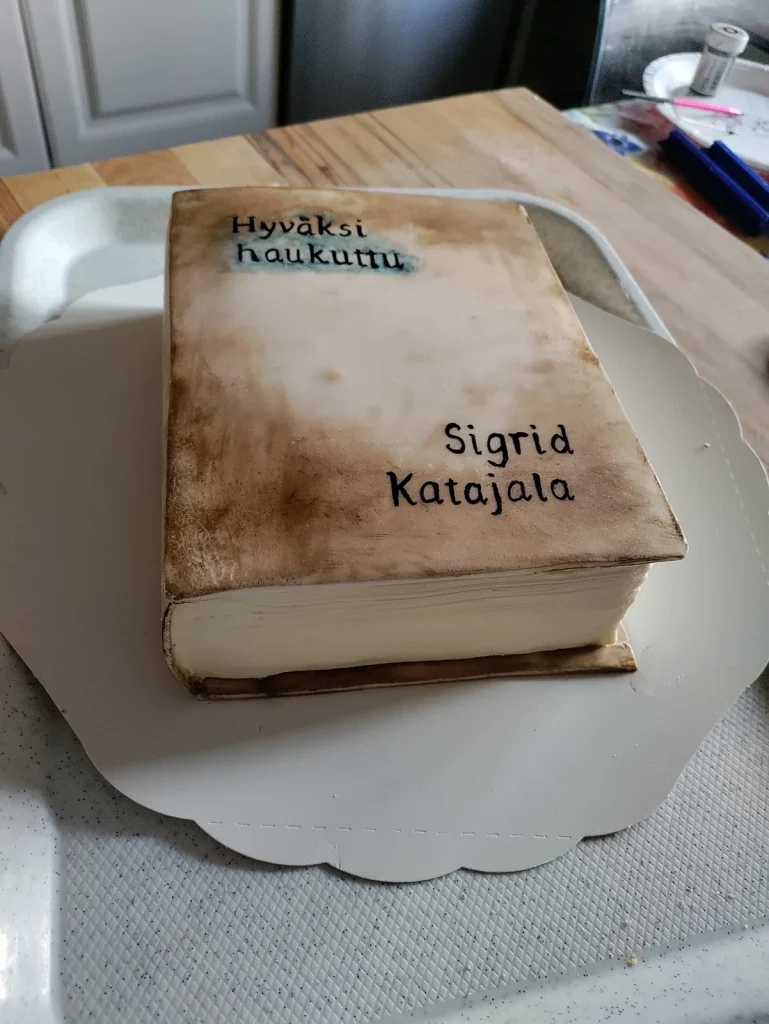 Kirjan muotoinen tilauskakku, jonka kannessa lukee Hyväksi haukuttu